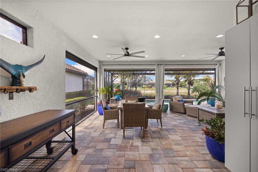 View of patio / terrace with a sunroom, a ceiling fan, and an outdoor living / dining area