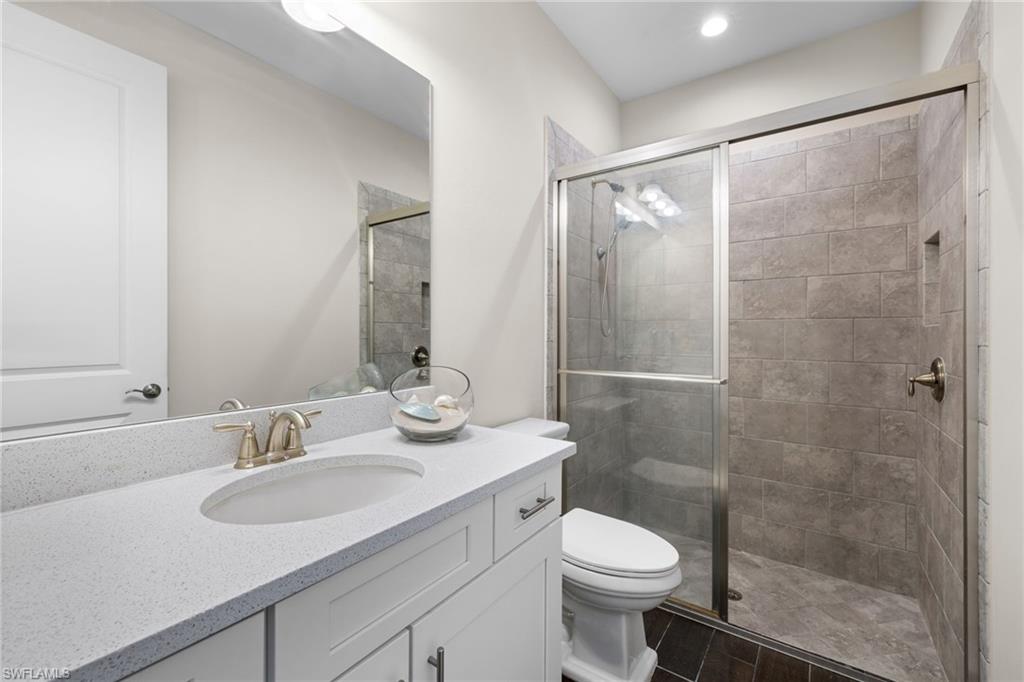 Full bath featuring vanity, a shower stall, wood tiled floors, and recessed lighting