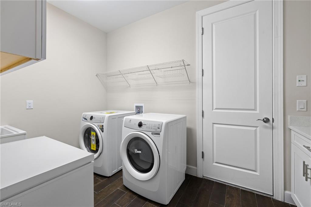 Laundry area featuring cabinet space, wood finish floors, and washing machine and dryer