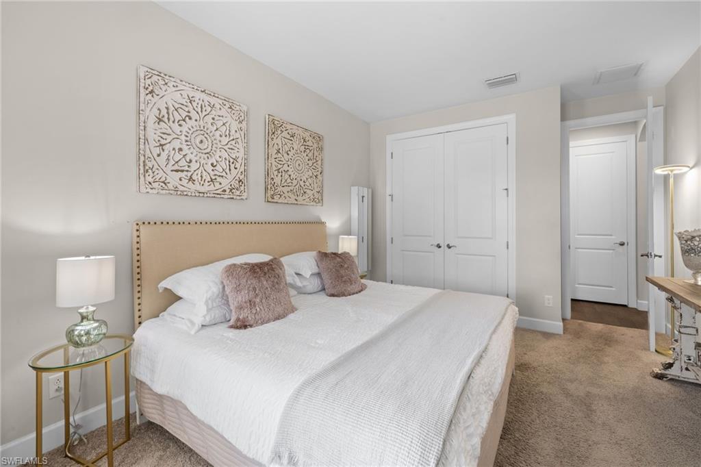 Bedroom with light carpet and a closet