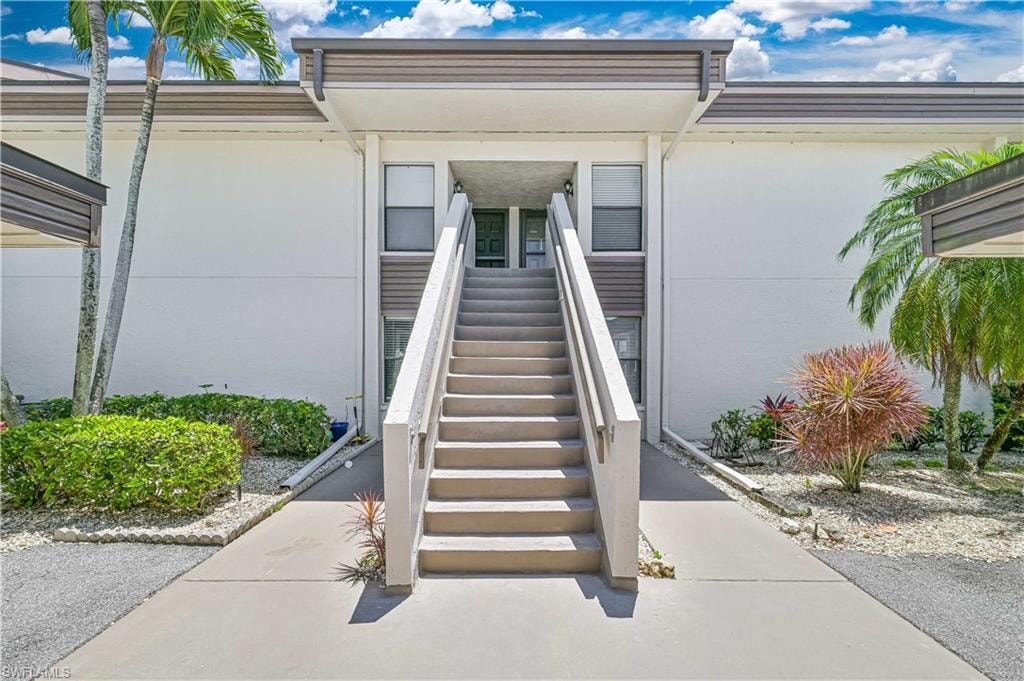 Doorway to property featuring stucco siding