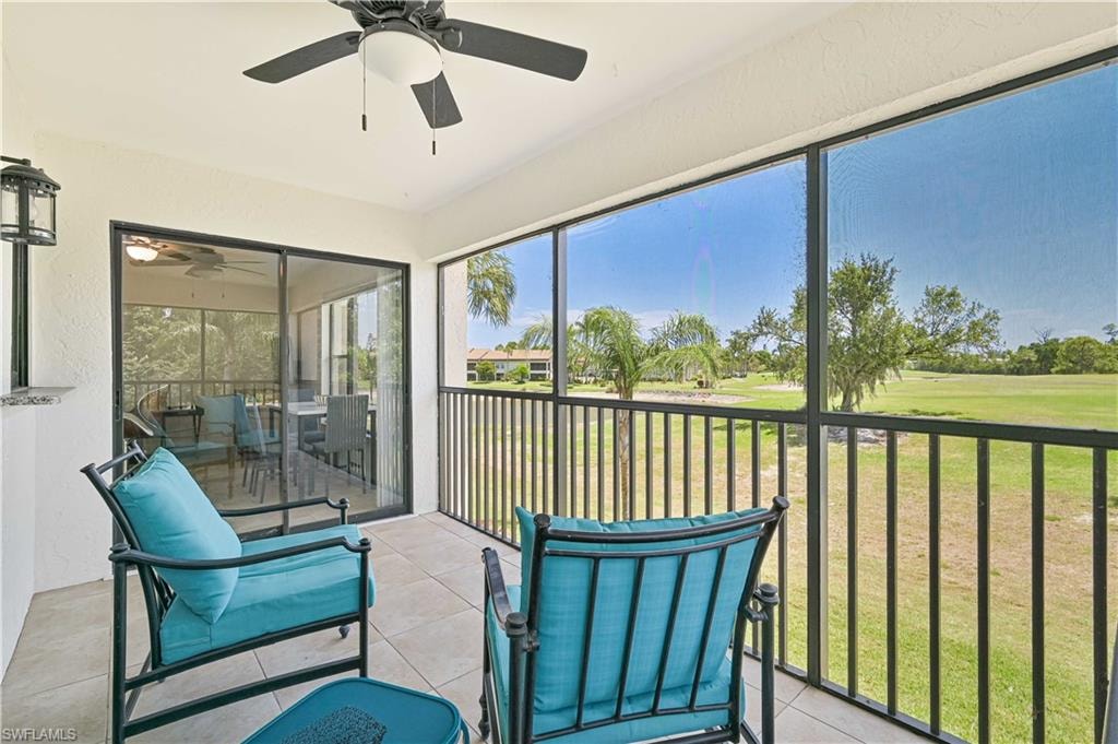 Sunroom featuring a ceiling fan, golf course view, and a balcony