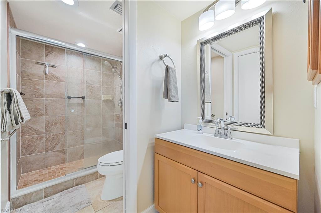 Full bathroom featuring vanity, a shower stall, light tile patterned flooring, and recessed lighting