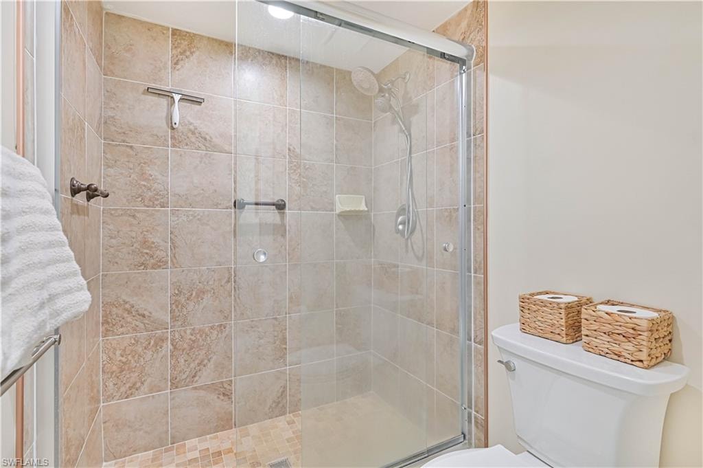 Full bathroom with toilet and a shower stall