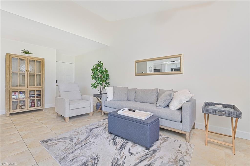 Living area with light tile patterned flooring and a high ceiling