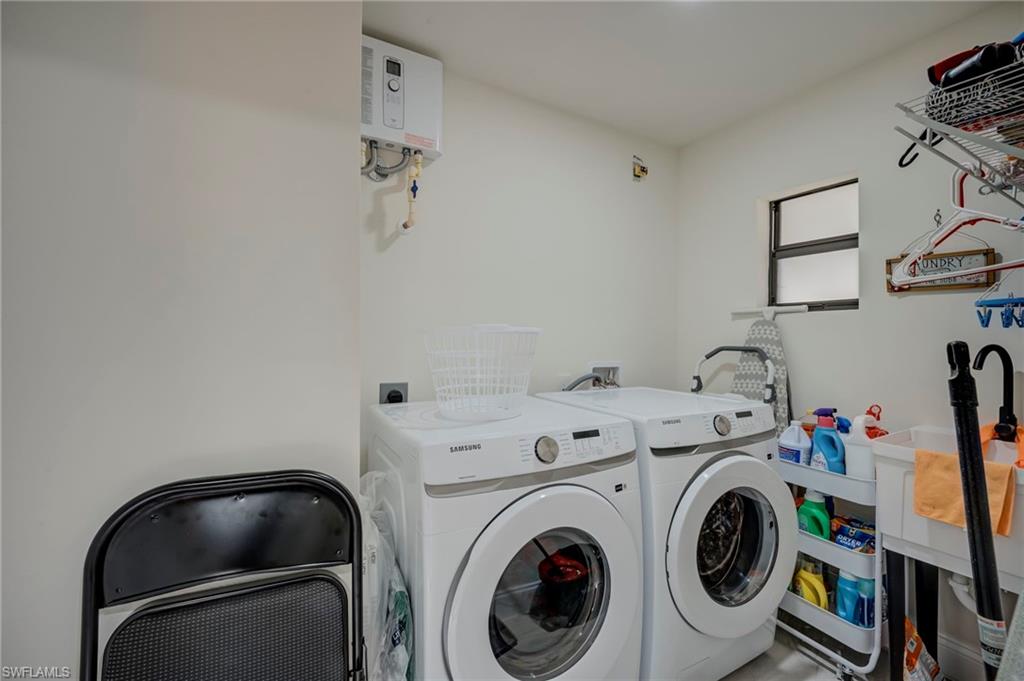 Laundry area with water heater and separate washer and dryer
