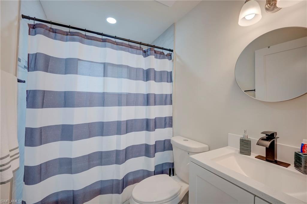 Bathroom with vanity, a shower with shower curtain, and recessed lighting