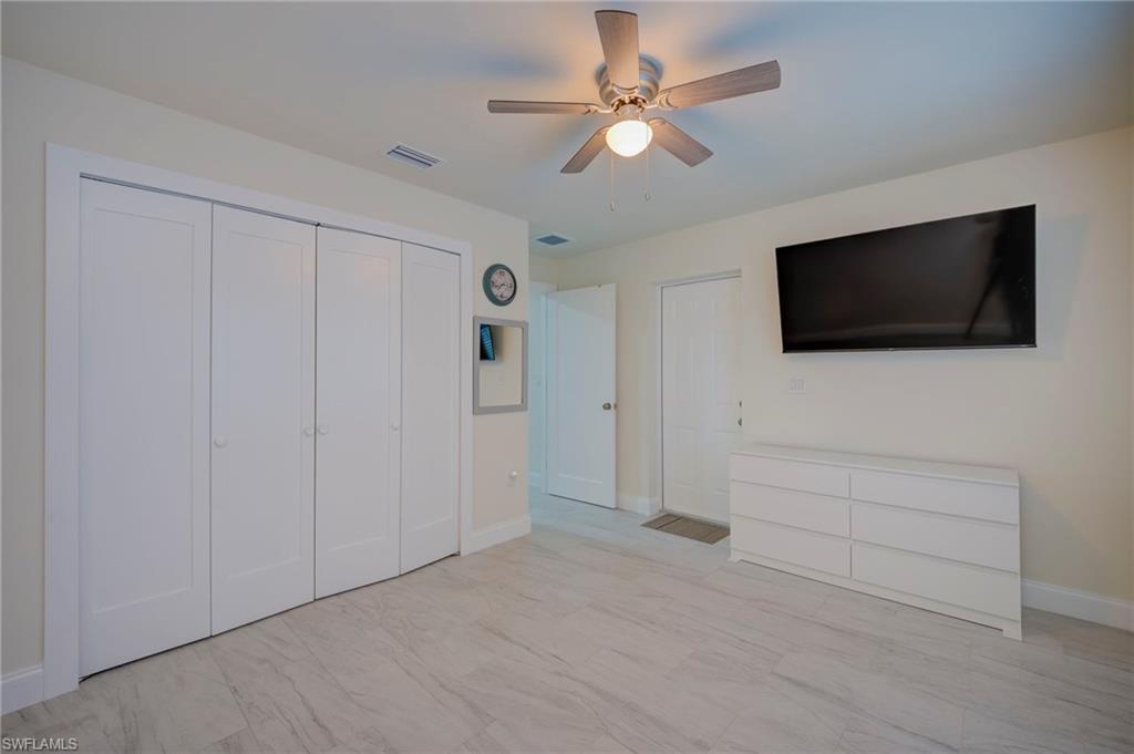 Unfurnished bedroom with ceiling fan and a closet