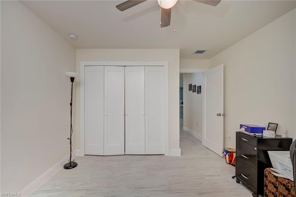 Bedroom featuring light marble finish floors, a closet, and ceiling fan