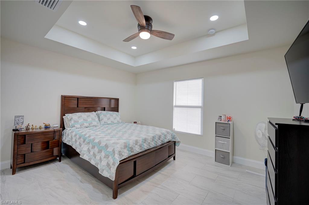 Bedroom featuring a raised ceiling, a ceiling fan, and recessed lighting