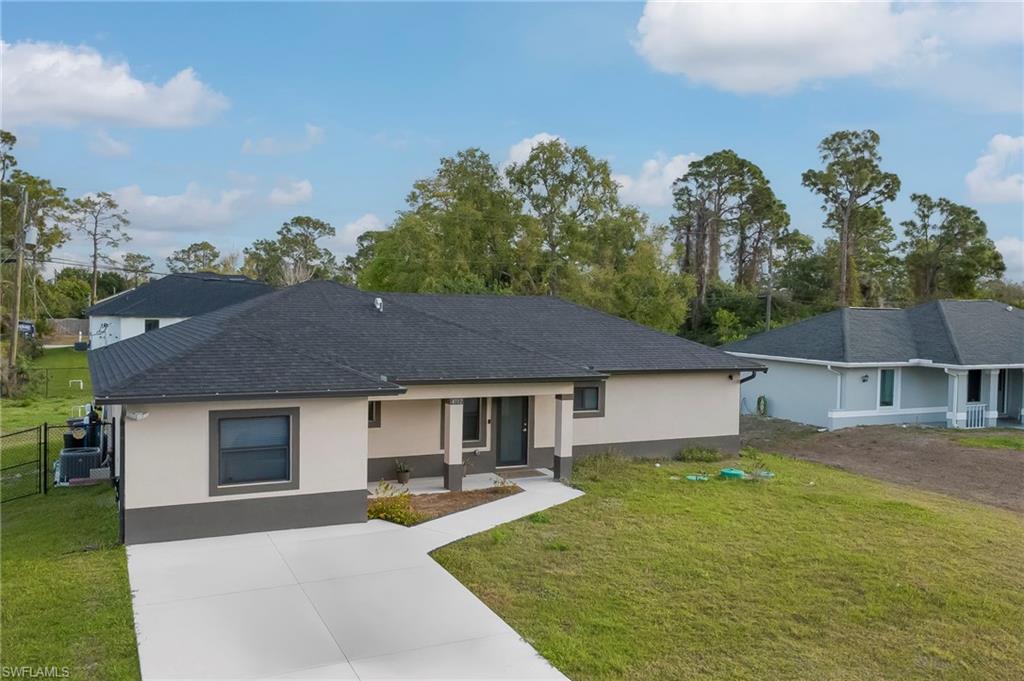 Single story home with stucco siding, concrete driveway, and roof with shingles