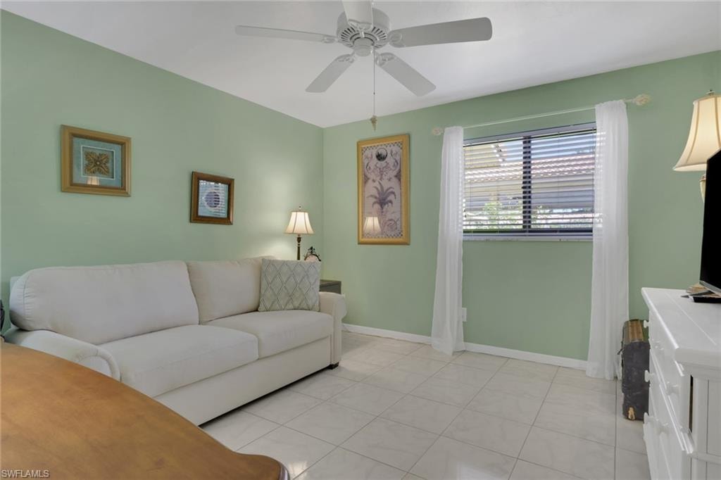 Living area featuring ceiling fan and light tile patterned floors