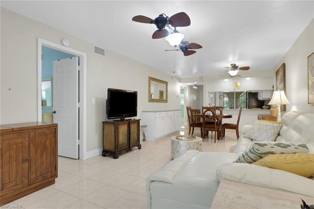 Living area featuring a ceiling fan and light tile patterned floors