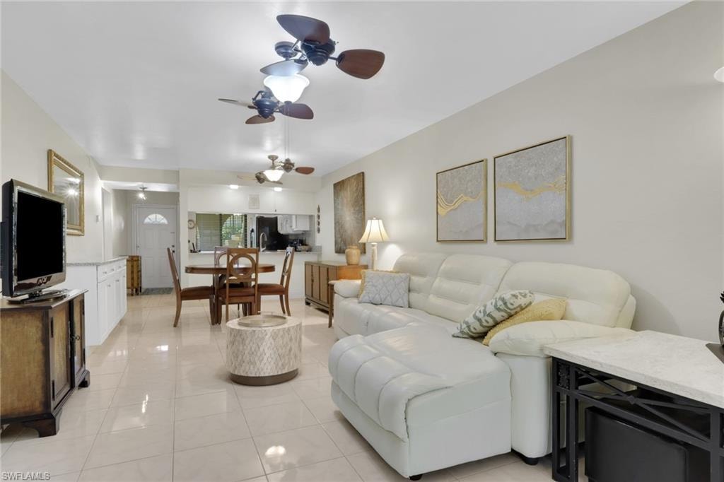 Living area featuring ceiling fan and light tile patterned floors