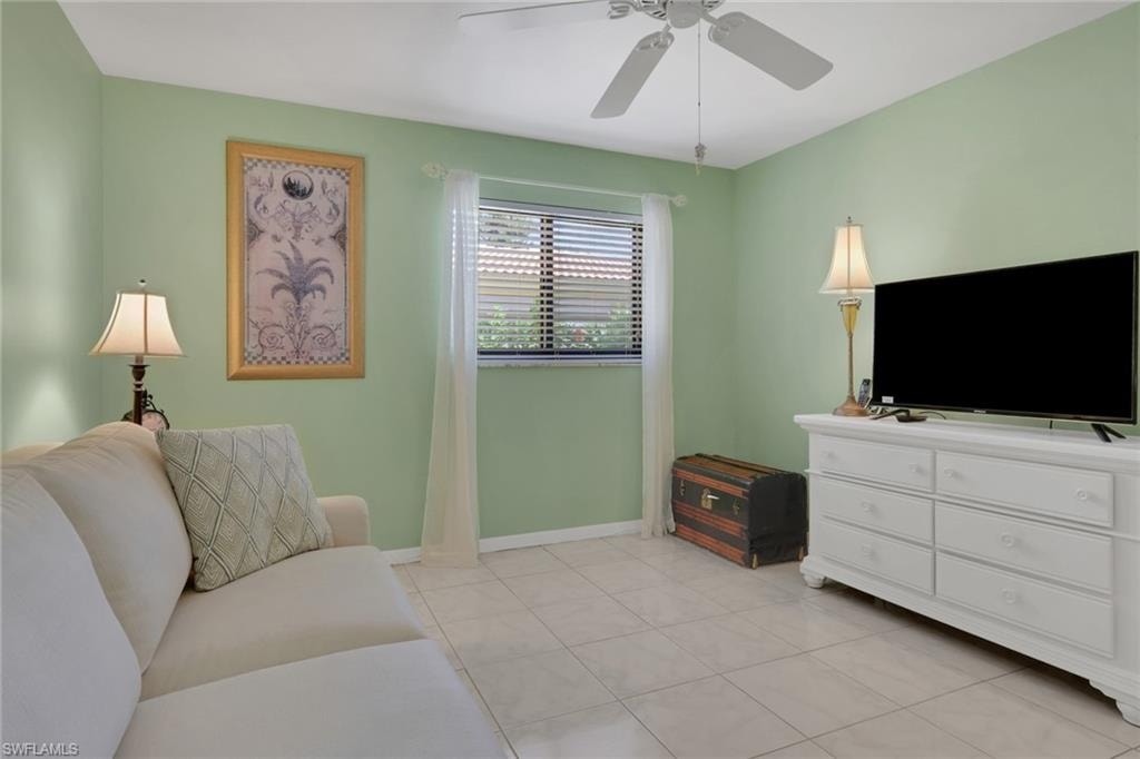 Living area featuring ceiling fan and light tile patterned floors