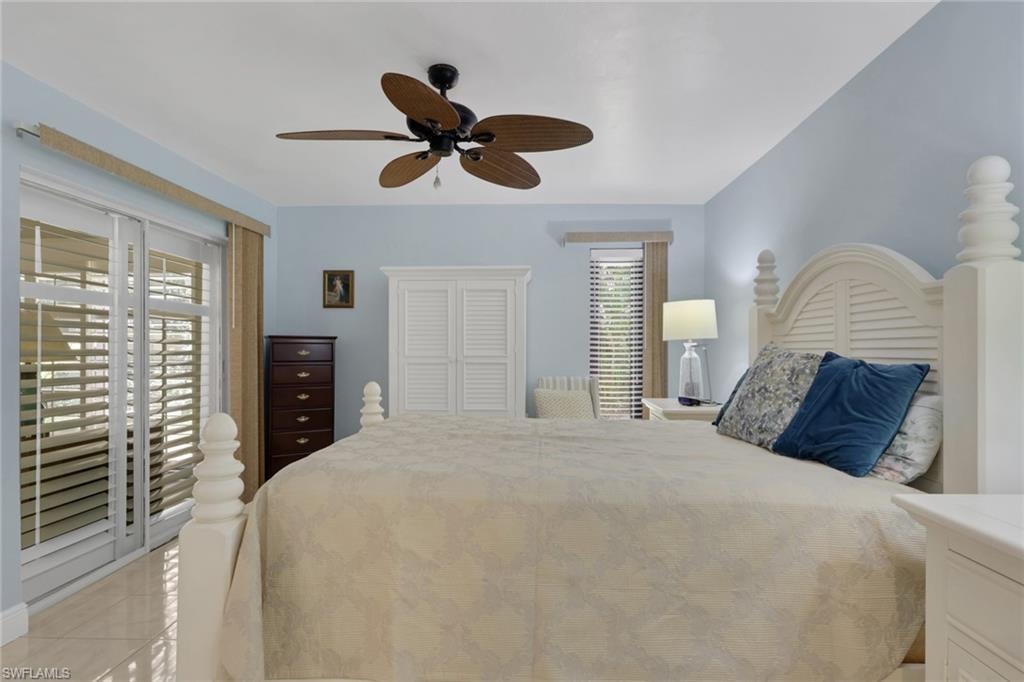 Bedroom featuring access to outside, light tile patterned floors, and ceiling fan