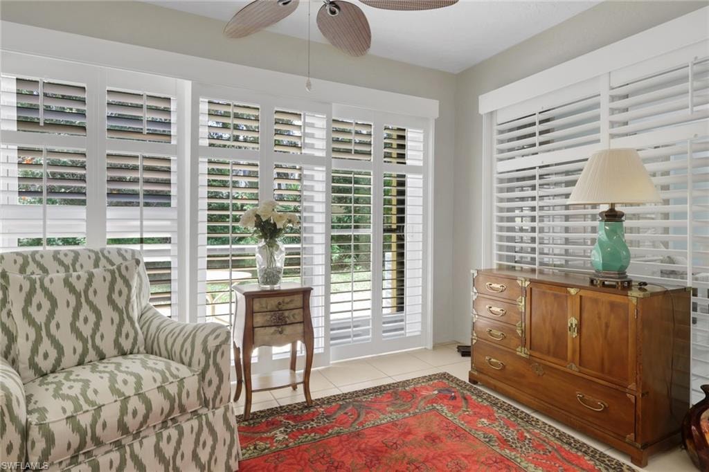 Living area with a ceiling fan and light tile patterned floors