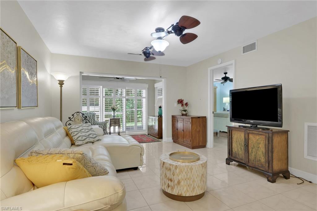 Living room featuring light tile patterned floors and ceiling fan