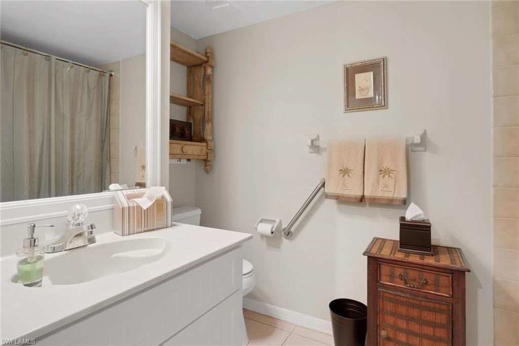 Bathroom with a shower with shower curtain, vanity, and light tile patterned floors