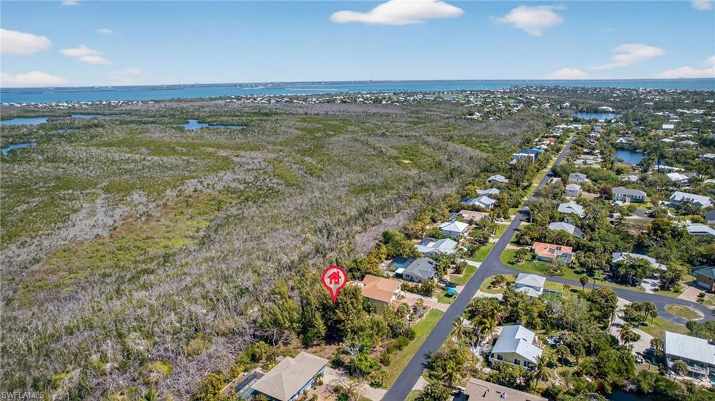 Aerial perspective of suburban area featuring a nearby body of water
