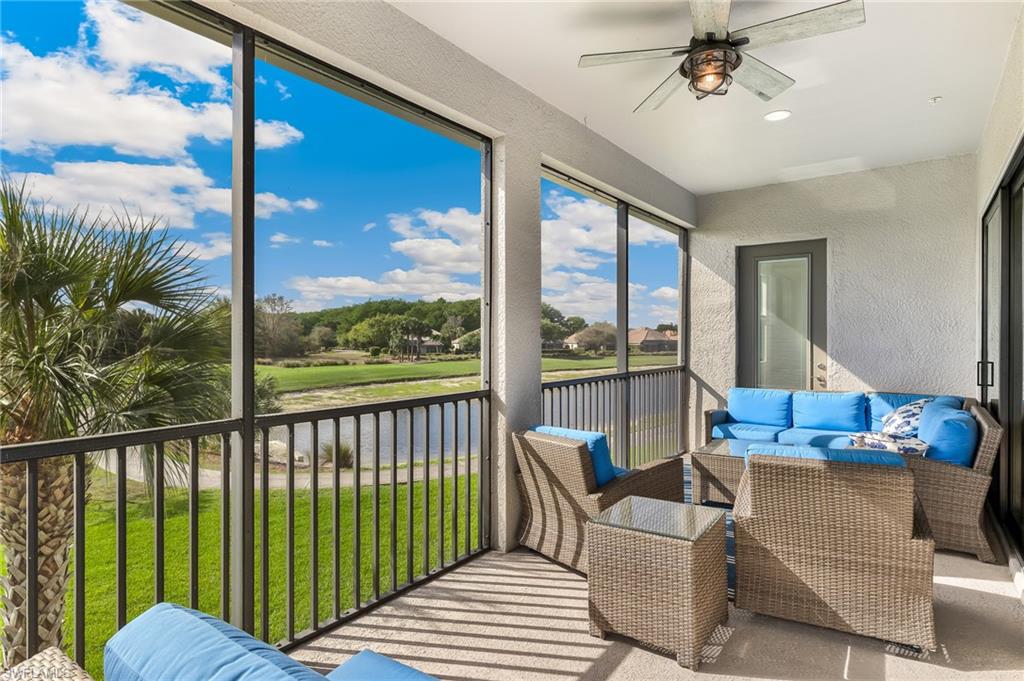 Sunroom with a ceiling fan, a balcony, an outdoor living space, and a water view