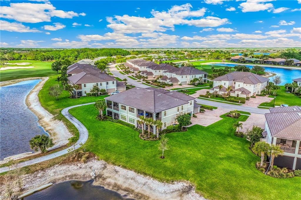 Aerial view of residential area featuring a nearby body of water and a golf course