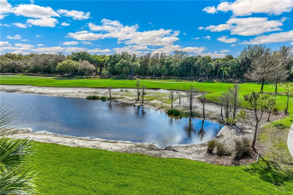 Water view featuring a golf course and a tree filled landscape