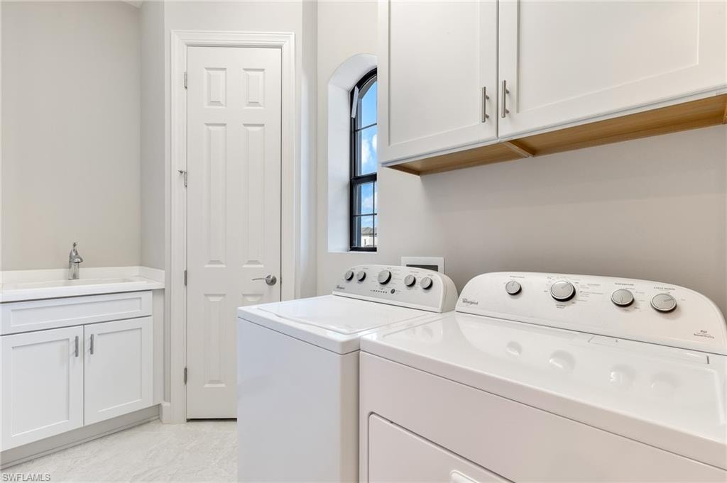Laundry area featuring cabinet space and separate washer and dryer