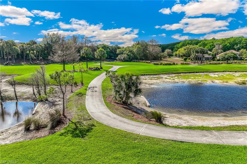 View of property's community featuring a water view, view of scattered trees, and golf course view