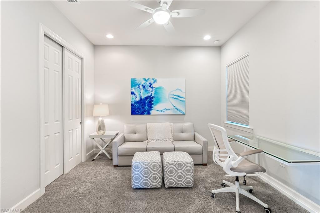 Carpeted office space with a ceiling fan and recessed lighting