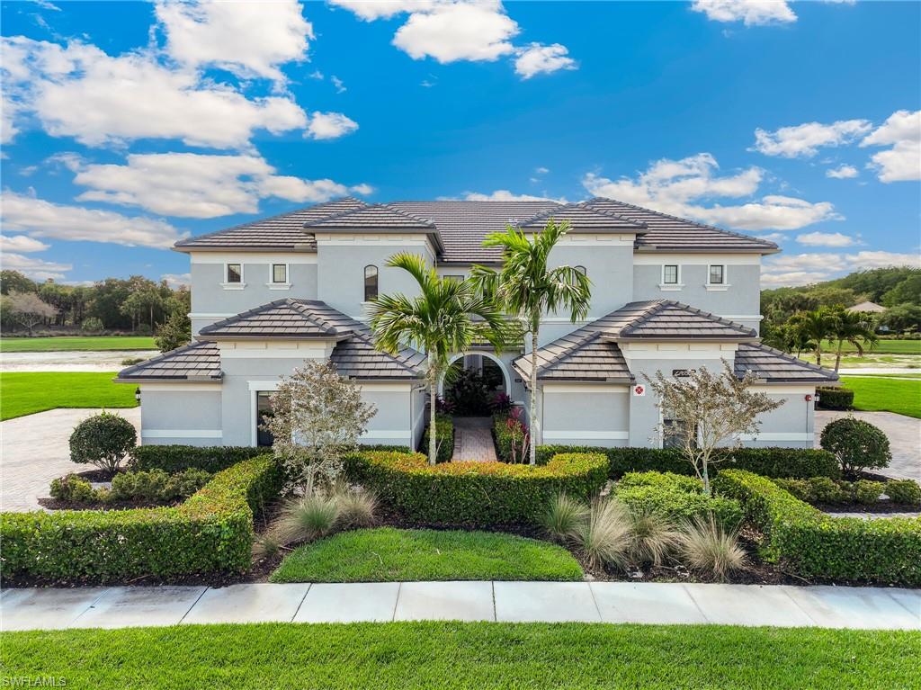 Mediterranean / spanish-style home featuring stucco siding, driveway, a front yard, and a tiled roof