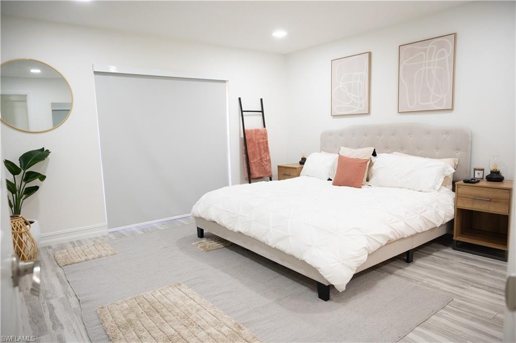 Bedroom with light wood-type flooring and recessed lighting