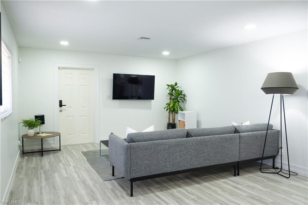 Living area with light wood-style floors and recessed lighting