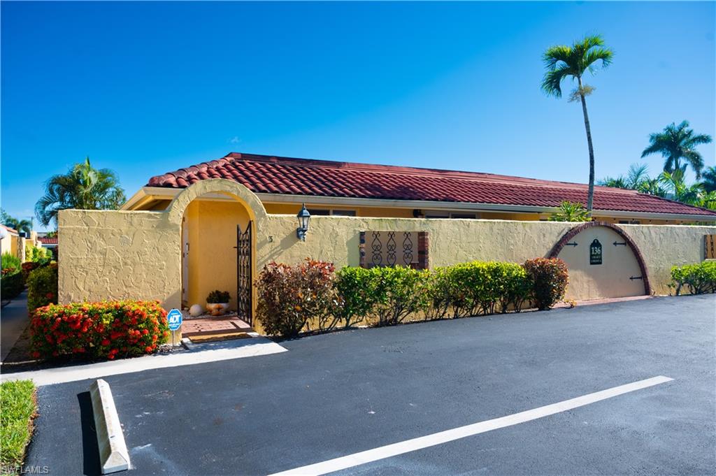 Mediterranean / spanish-style home with uncovered parking, a tile roof, and stucco siding