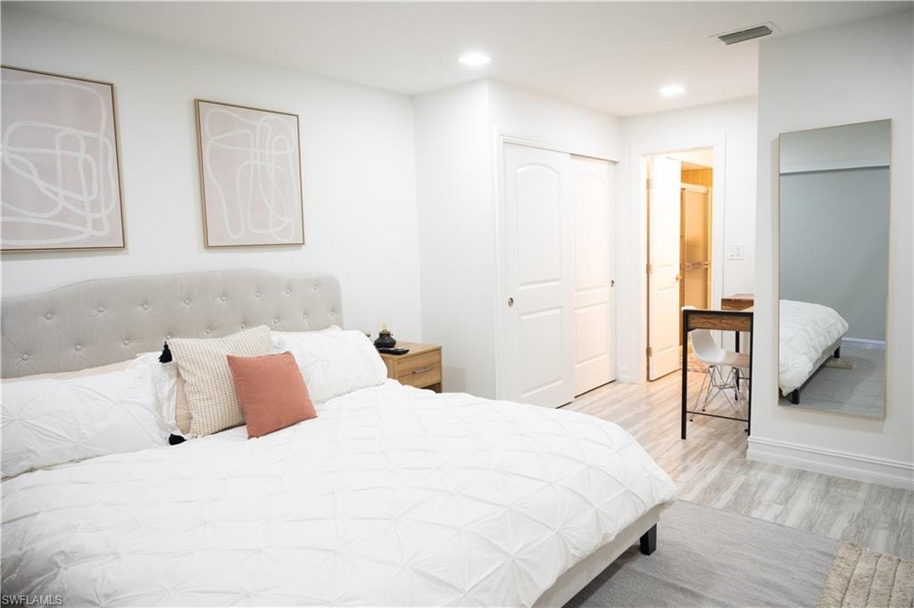 Bedroom featuring light wood finished floors, a closet, and recessed lighting