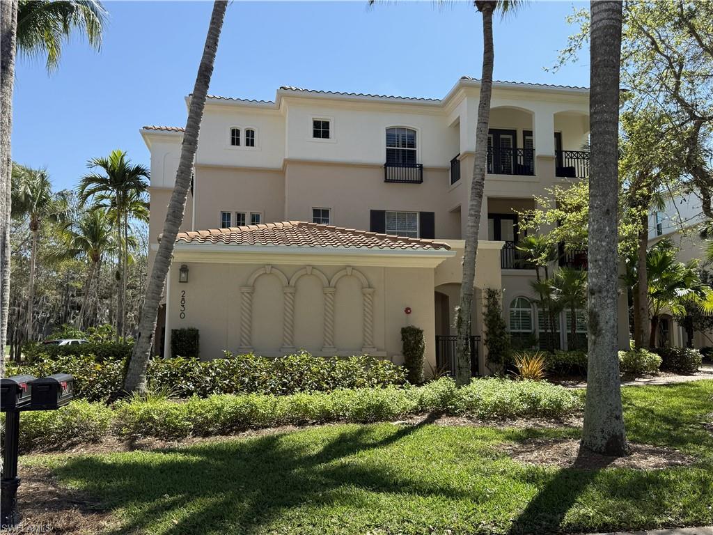 View of front of condo, 2 car garage and extra parking to the left of the front of the condo