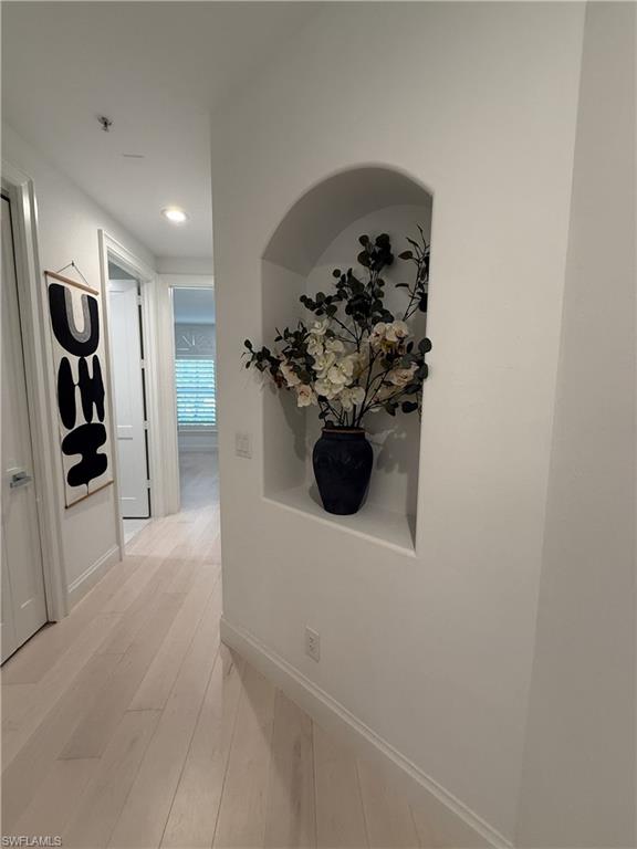 Corridor featuring light wood-type flooring and recessed lighting