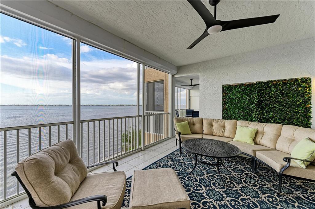 Sunroom / solarium featuring an outdoor hangout area, ceiling fan, and a water view