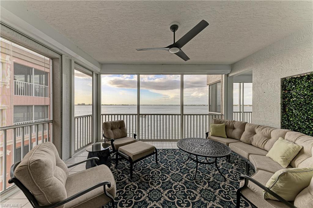 Sunroom featuring a textured ceiling, a textured wall, and a water view
