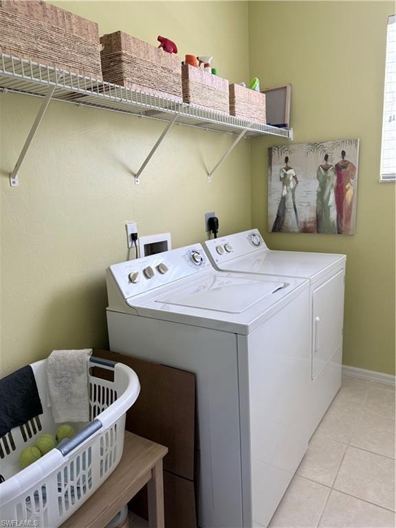 Laundry room featuring washing machine and dryer and light tile patterned floors