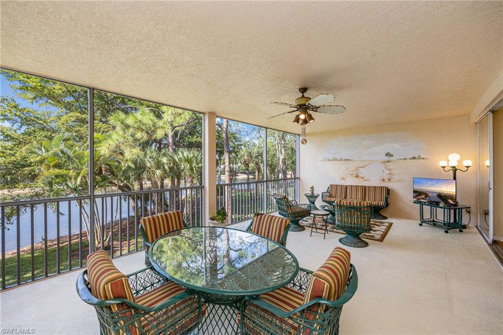 Sunroom featuring an outdoor living / dining area, a ceiling fan, and a water view