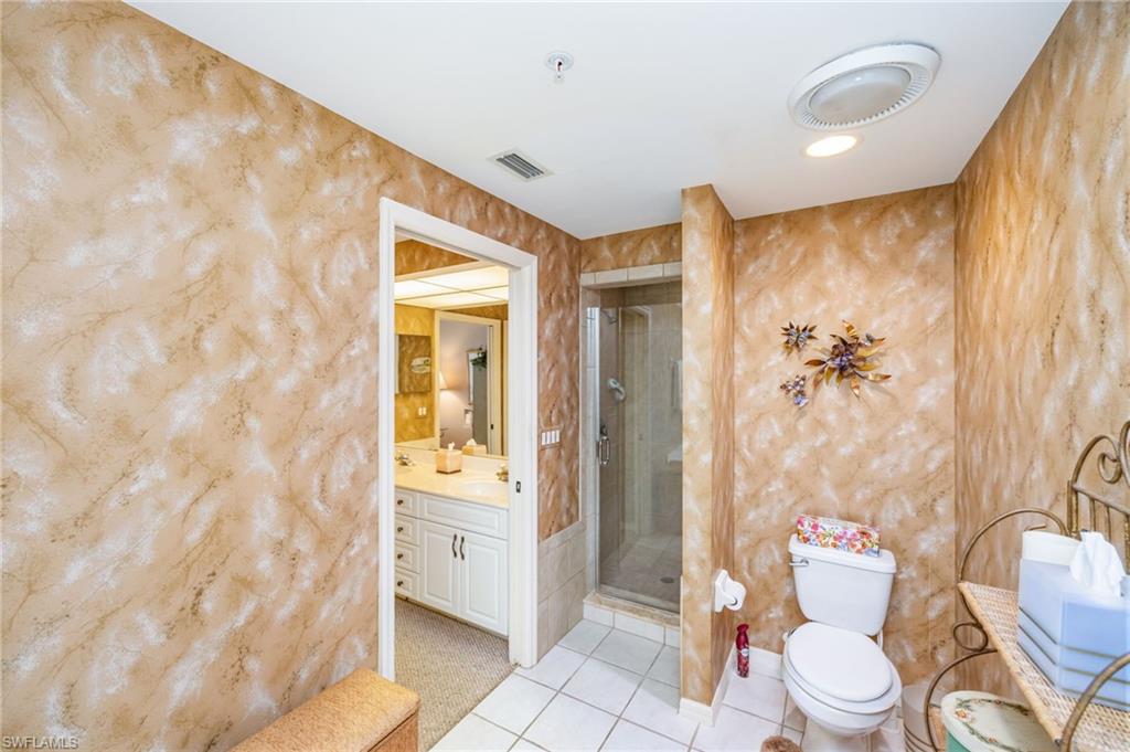 Full bath featuring vanity, a shower stall, light tile patterned flooring, and recessed lighting