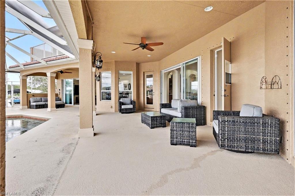 View of patio featuring outdoor seating, ceiling fan, a lanai, and an outdoor pool