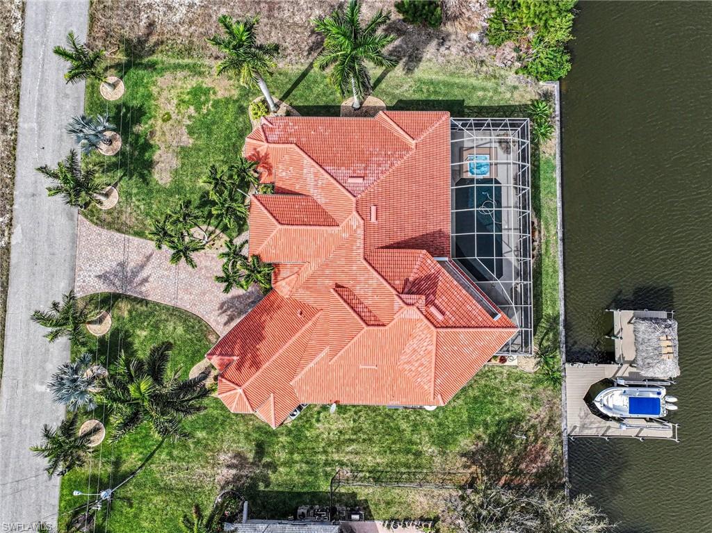 Mediterranean / spanish-style house with a front lawn, stucco siding, a tile roof, decorative driveway, and a garage