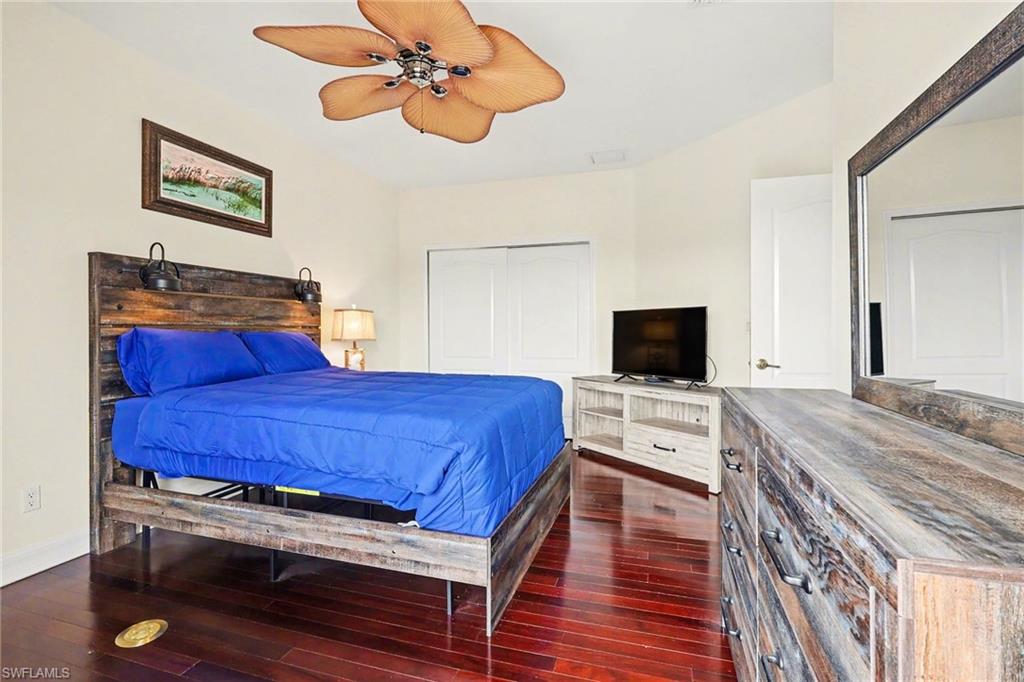 Bedroom featuring a closet, dark wood-style flooring, and ceiling fan