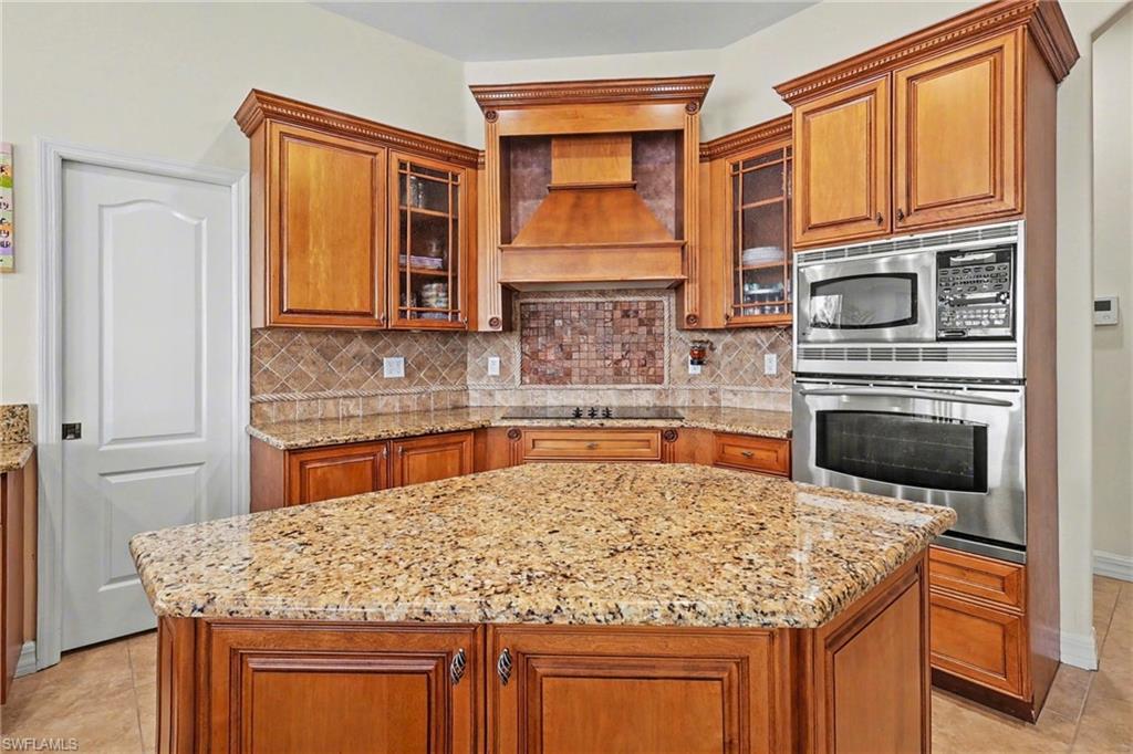 Kitchen featuring light tile patterned floors, wood finish cabinetry, and stainless steel appliances
