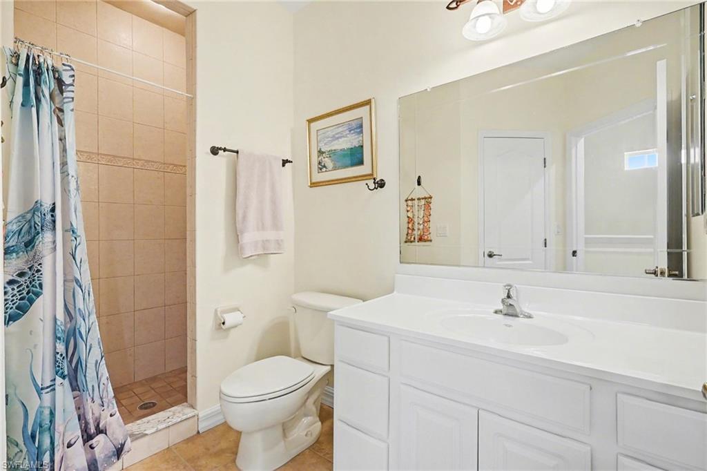 Full bathroom featuring a shower stall, vanity, and light tile patterned floors