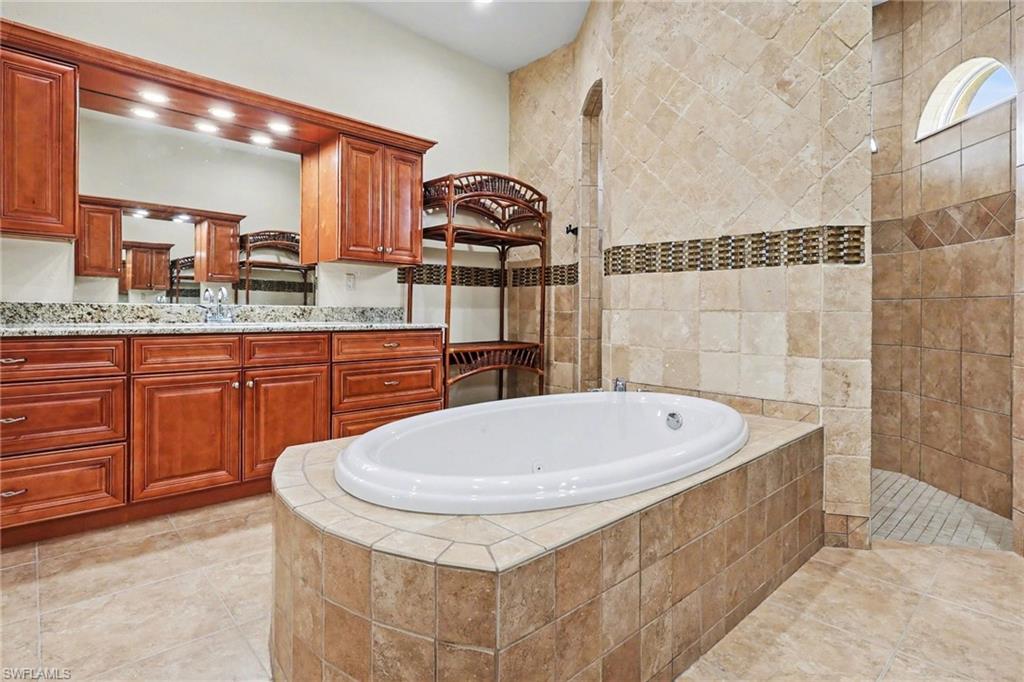 Full bath with vanity, walk in shower, and a bath