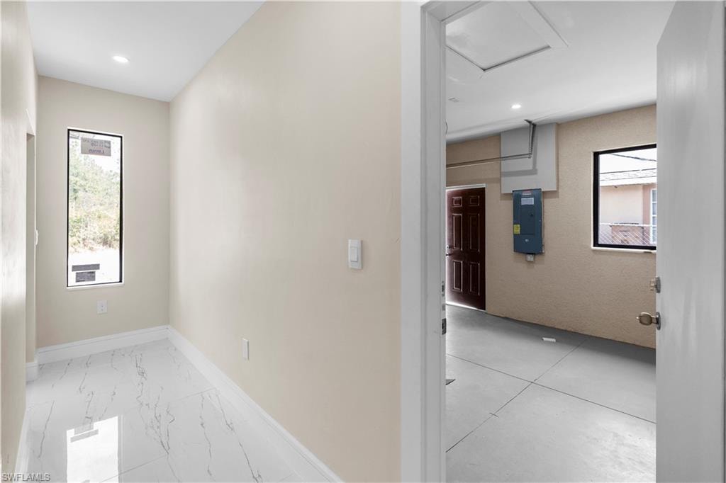 Corridor with electric panel and recessed lighting