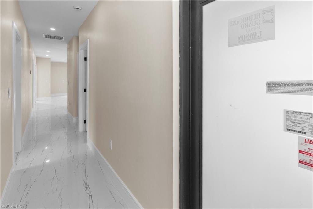 Hallway featuring recessed lighting, light marble finish flooring, and a heating unit